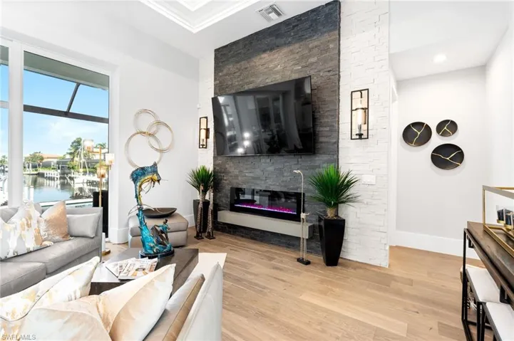 Living room featuring wood finished floors and a glass covered fireplace