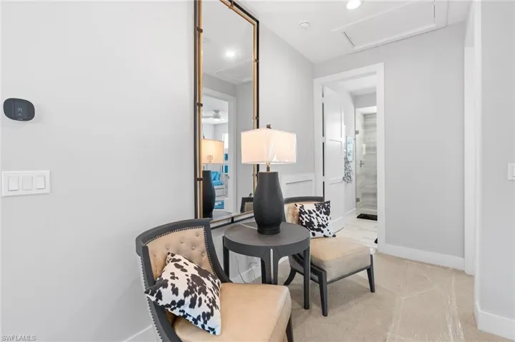 Sitting room with recessed lighting and light colored carpet