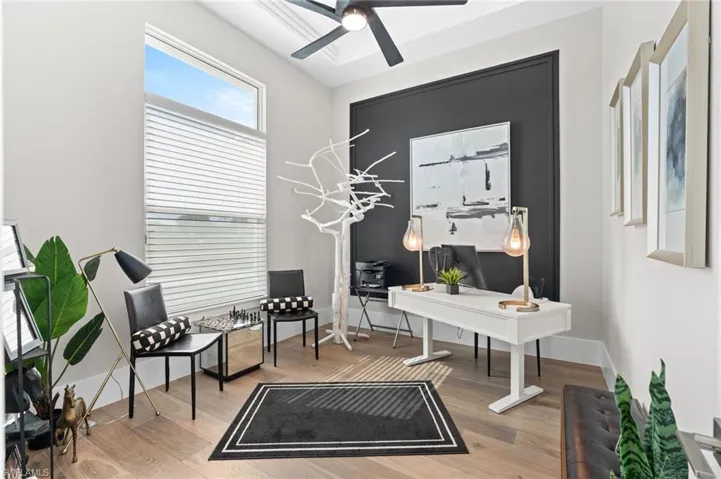 Office space with light wood-style floors and ceiling fan
