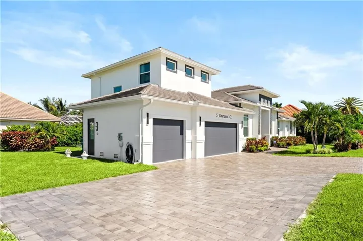 View of front of house with stucco siding, a front lawn, decorative driveway, and a tile roof