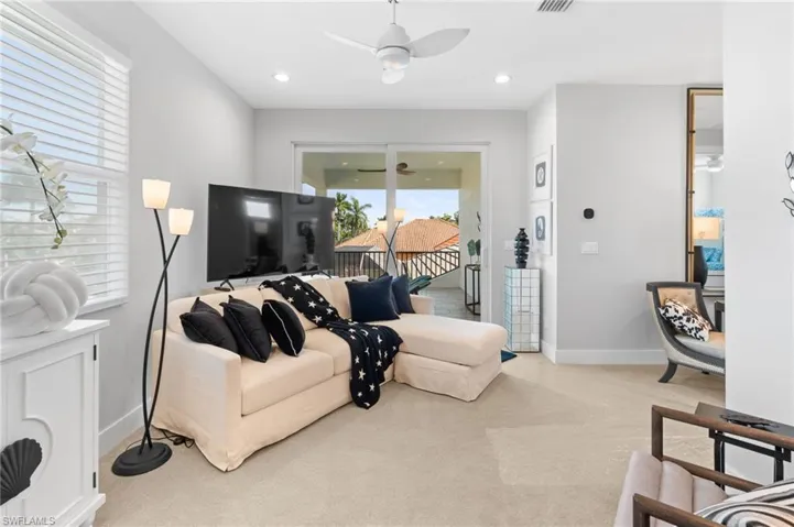Living area with light carpet, ceiling fan, and recessed lighting