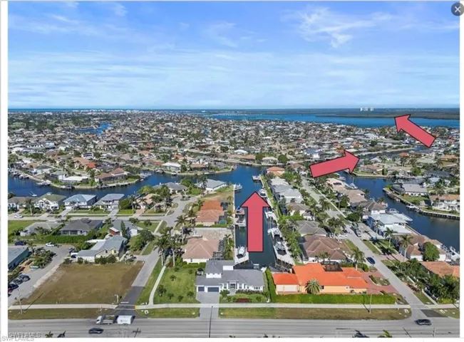 Aerial perspective of suburban area featuring a nearby body of water