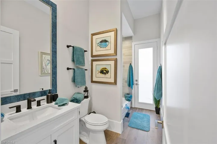 Bathroom with vanity, light wood finished floors, and shower / bath combo with shower curtain