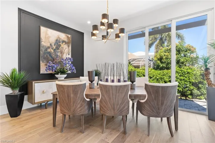 Dining space with light wood finished floors, a chandelier, and recessed lighting