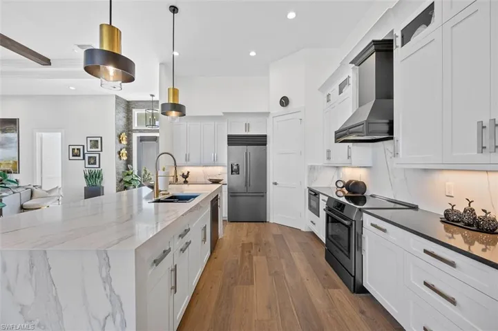 Kitchen with white cabinets, appliances with stainless steel finishes, tasteful backsplash, dark stone counters, and recessed lighting