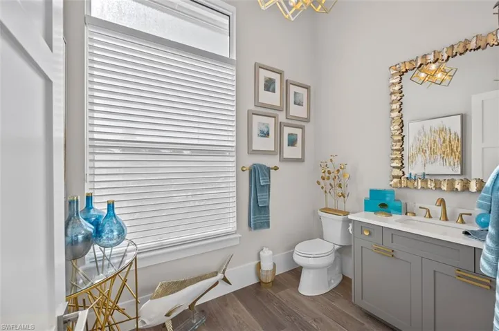 Half bath featuring vanity, dark wood-type flooring, and a chandelier