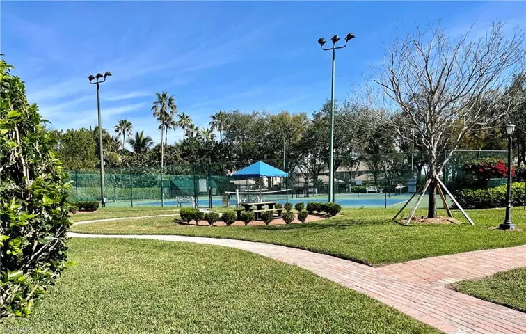View of community with a yard and tennis court