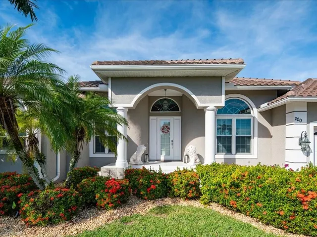 View of exterior entry with a porch, stucco siding, and a tiled roof