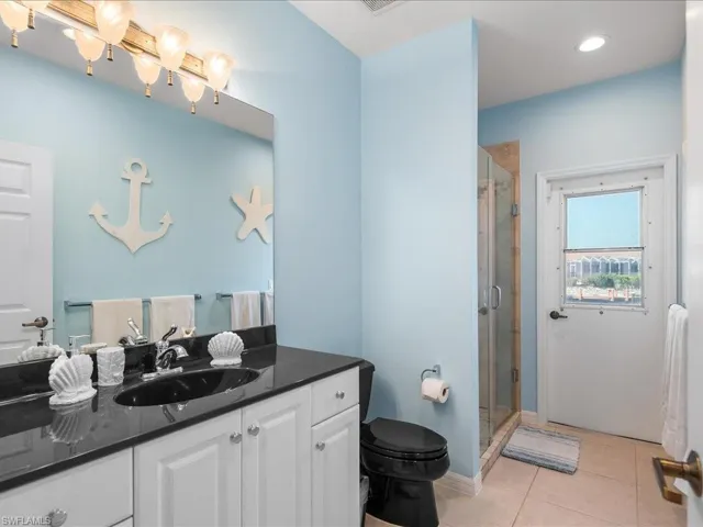Bathroom with vanity, light tile patterned floors, a shower stall, and recessed lighting