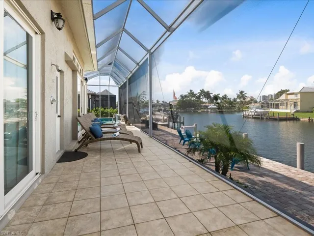 Sunroom / solarium with a water view, a patio, and a pool
