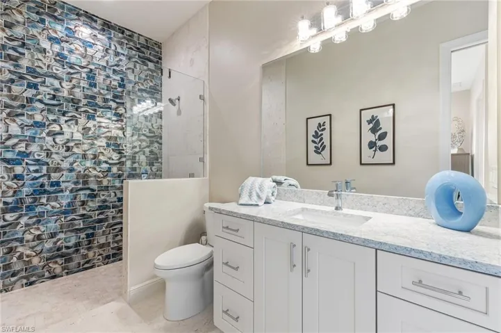 Full bath featuring a walk in shower, vanity, and light tile patterned floors