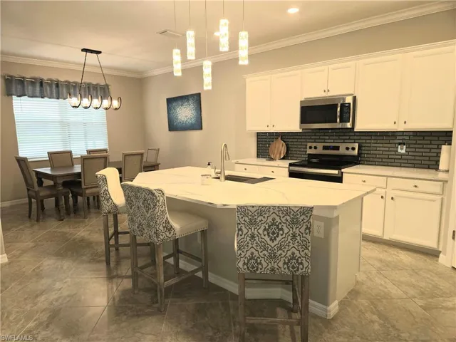 White cabinets, light quartz countertops, wide island, glass backsplash, stainless steel applicances, large designer sink and more...