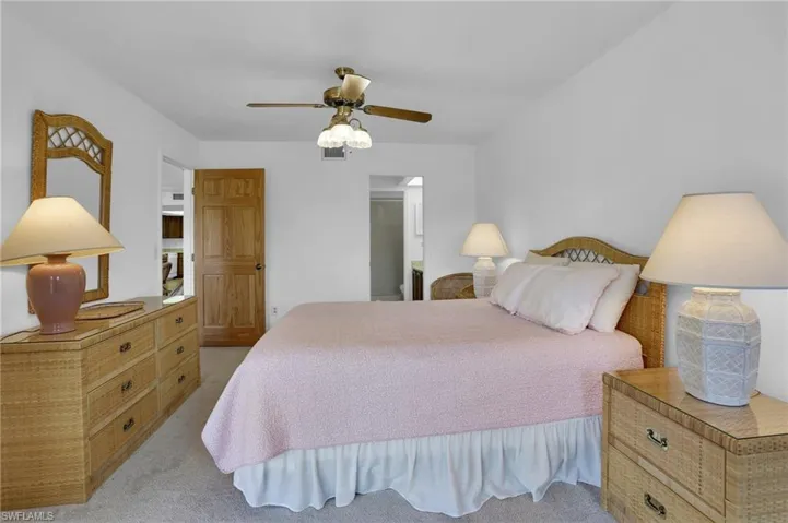Bedroom featuring ceiling fan, visible vents, and light colored carpet
