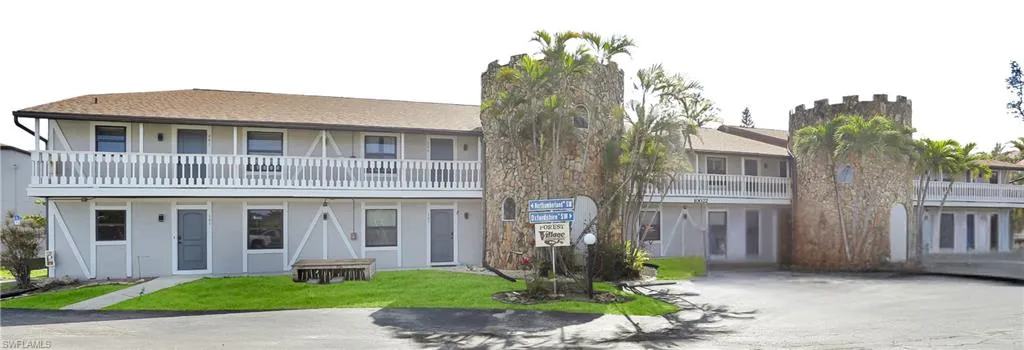 View of front of property featuring a chimney, a front lawn, and stucco siding