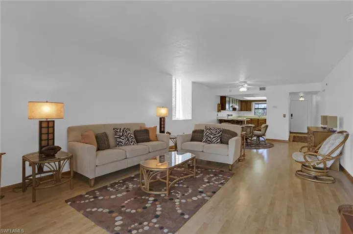 Living room featuring ceiling fan, light wood-type flooring, visible vents, and baseboards