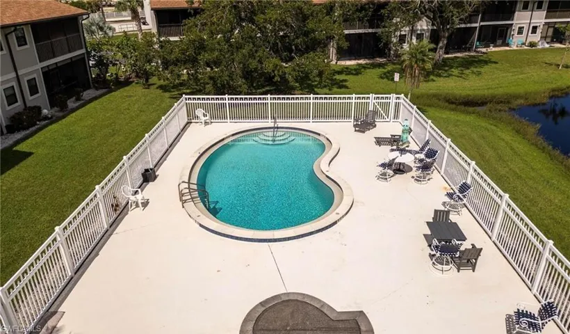 Community pool with a patio area and a water view