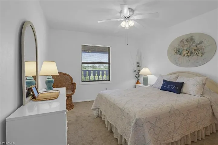 Bedroom with baseboards, a ceiling fan, and light colored carpet