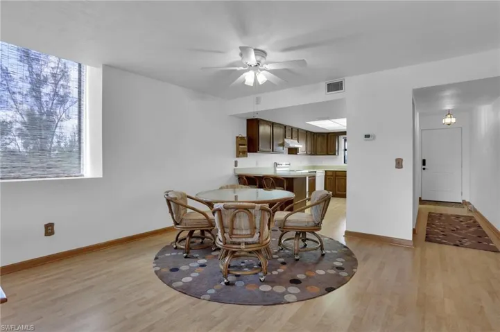 Dining room with light wood-style floors, visible vents, baseboards, and a ceiling fan