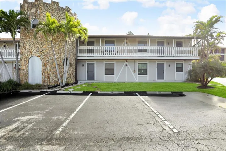 View of property featuring uncovered parking