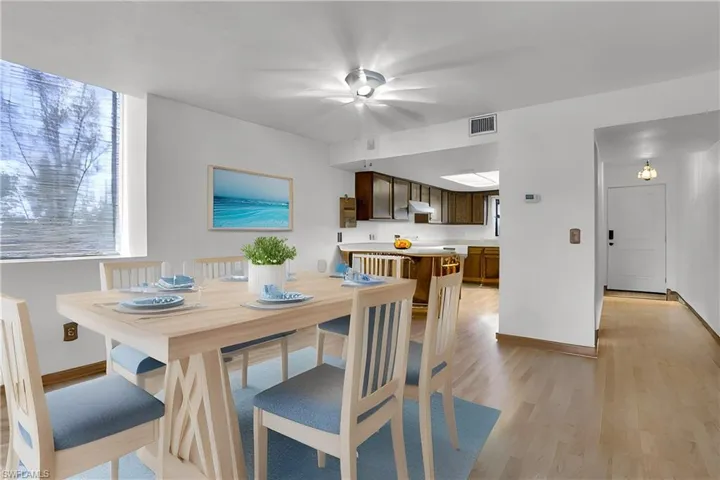 Virtually Stages Dining area with light wood finished floors, visible vents, and baseboards