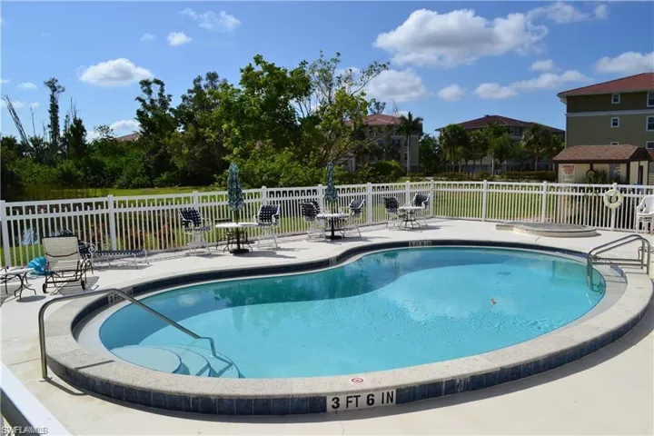Community pool featuring a patio area and fence