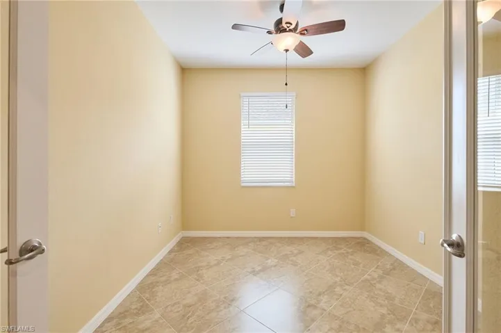 Empty room with light tile patterned flooring and ceiling fan