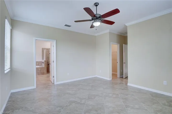 Unfurnished room with crown molding, ceiling fan, and light tile patterned floors