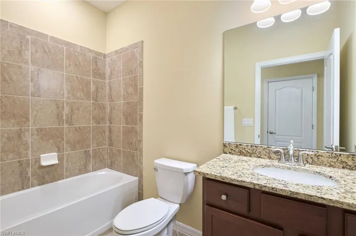 Full bathroom featuring vanity, toilet, and tiled shower / bath
