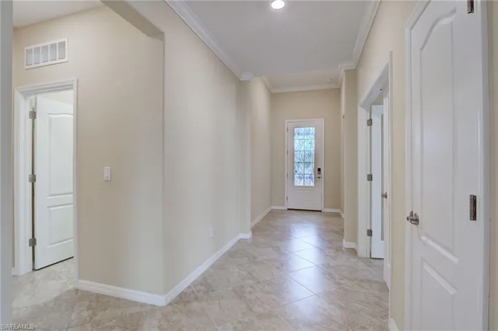 Tiled entrance foyer with ornamental molding