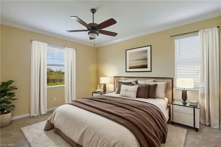 Bedroom featuring light tile patterned flooring, multiple windows, ceiling fan, and ornamental molding