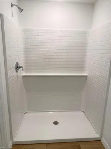 Full bath with a stall shower and wood finished floors