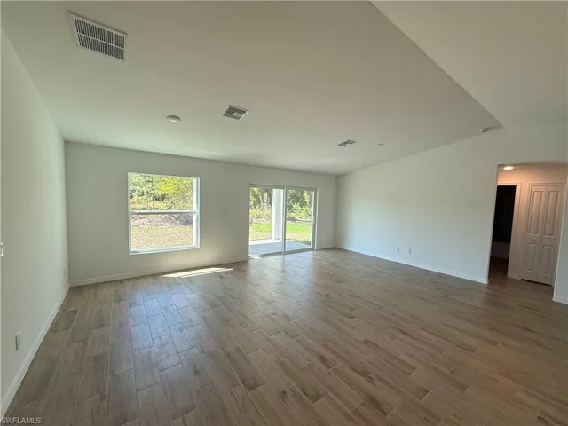 Empty room featuring wood tiled floors and baseboards