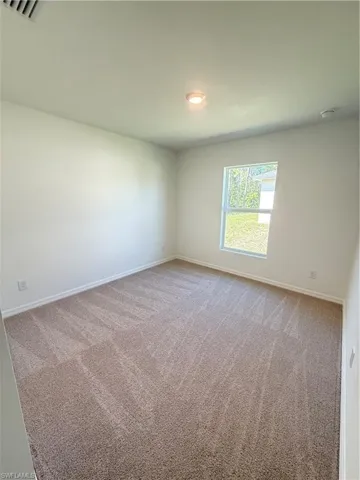 Spare room featuring light carpet