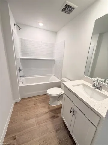Bathroom with vanity, light wood-style floors, and shower / tub combination