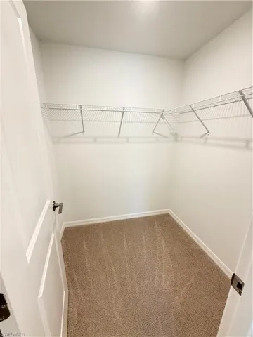 Walk in closet featuring dark carpet