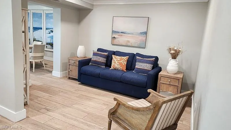 Community RM Living area with light wood finished floors and crown molding