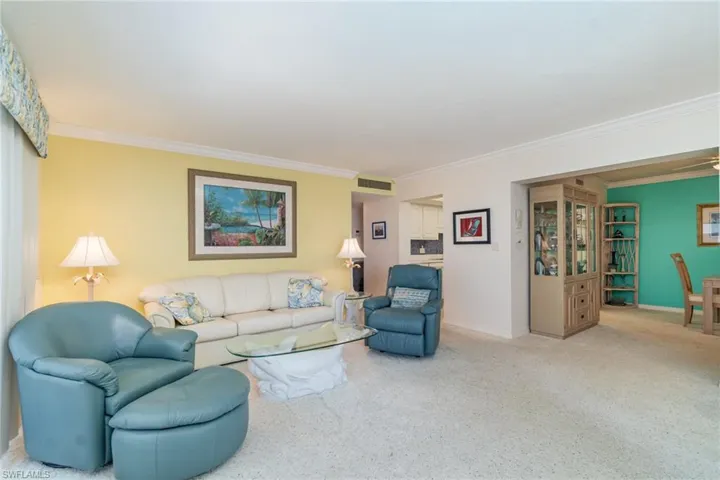 Living area with ornamental molding and carpet