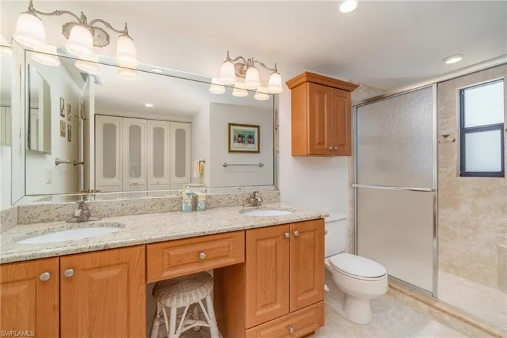 Primary, bathroom with a shower, double vanity, and laundry/linen closet with side by side W/D