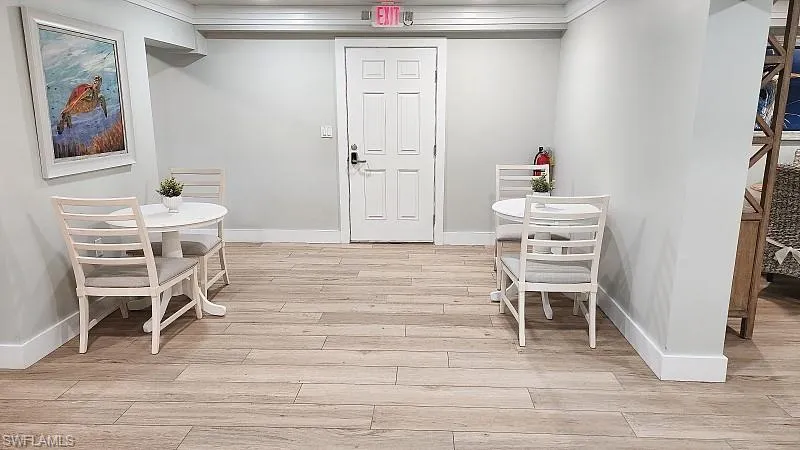Community RM Dining space with light wood-style flooring and crown molding