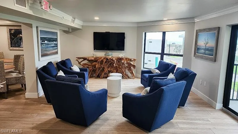 Community RM Living room featuring light wood-style floors, ornamental molding, and recessed lighting