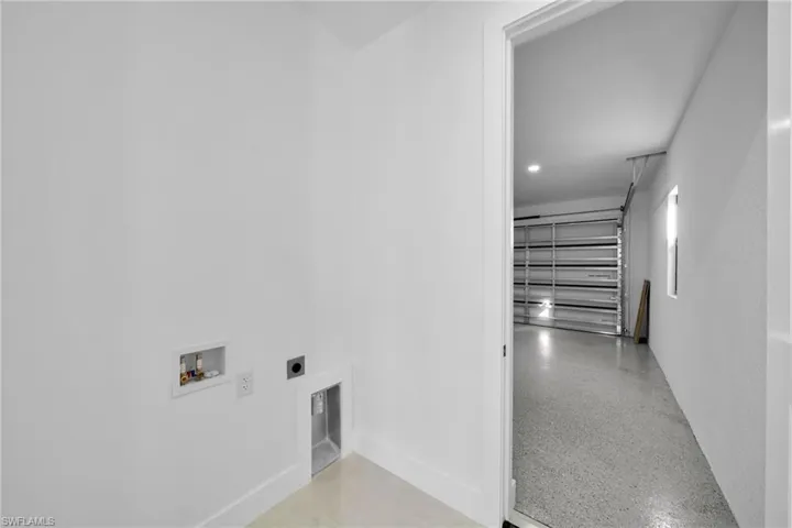 Laundry area featuring hookup for an electric dryer, washer hookup, and dark aggregate flooring