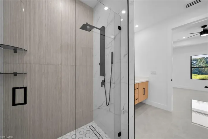 Full bathroom with vanity, a marble finish shower, light tile patterned floors, recessed lighting, and ceiling fan
