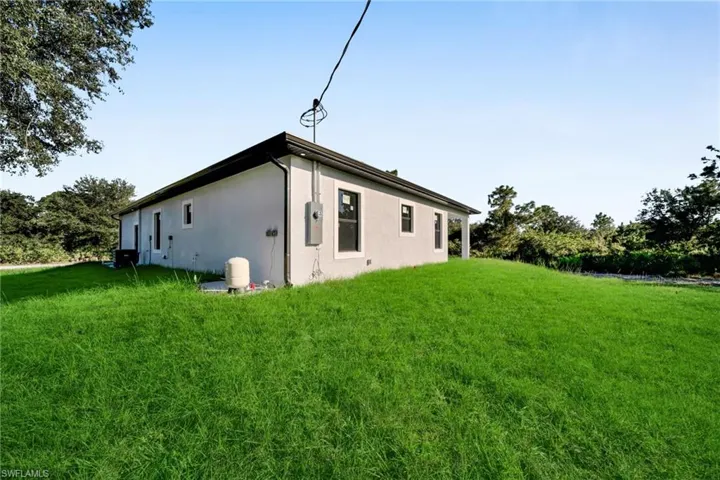 View of property exterior featuring a yard and stucco siding