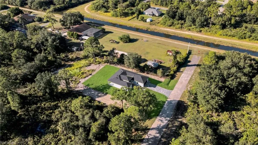 Aerial overview of property's location with a large body of water and a tree filled landscape