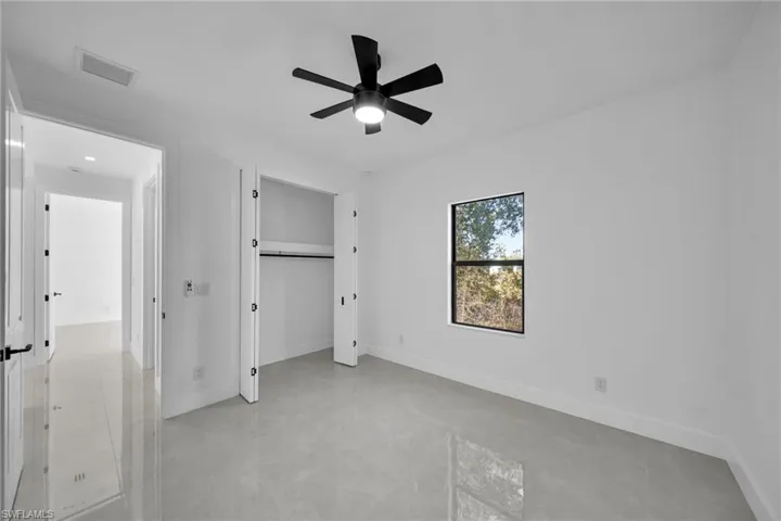 Unfurnished bedroom with a closet, ceiling fan, and light tile patterned floors