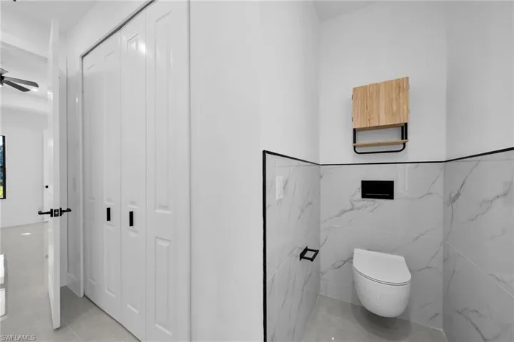 Bathroom featuring a closet, tile patterned flooring, and tile walls