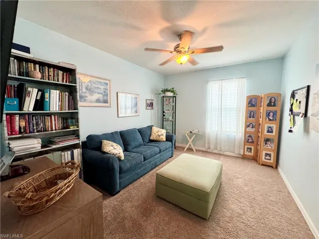 Den featuring a textured ceiling, carpet flooring, and ceiling fan