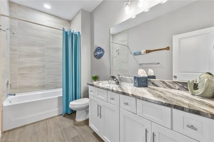 Full bathroom featuring vanity, light wood finished floors, and shower / bath combo