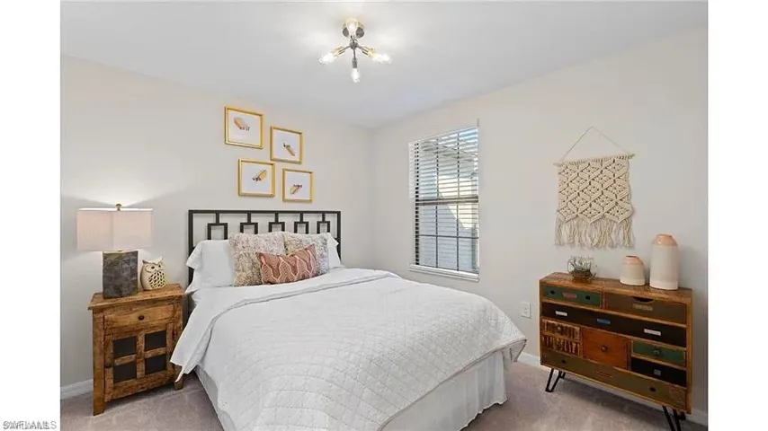 Bedroom featuring light colored carpet and baseboards