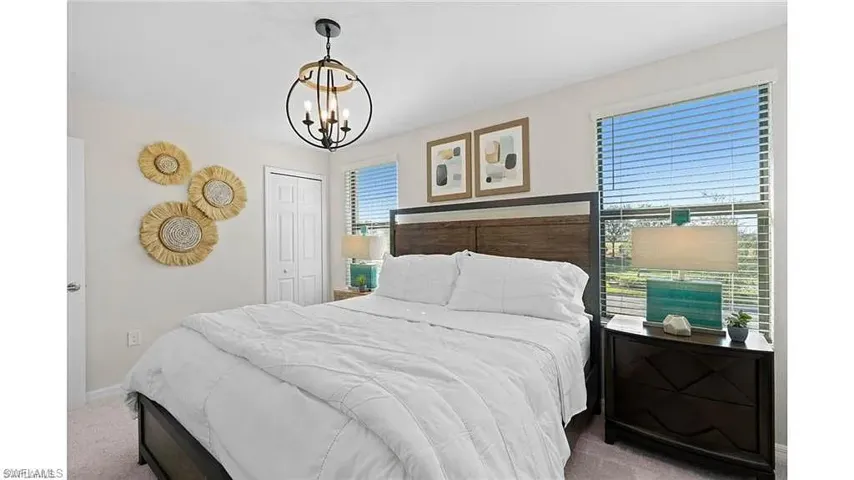 Bedroom featuring a chandelier, carpet flooring, and a closet